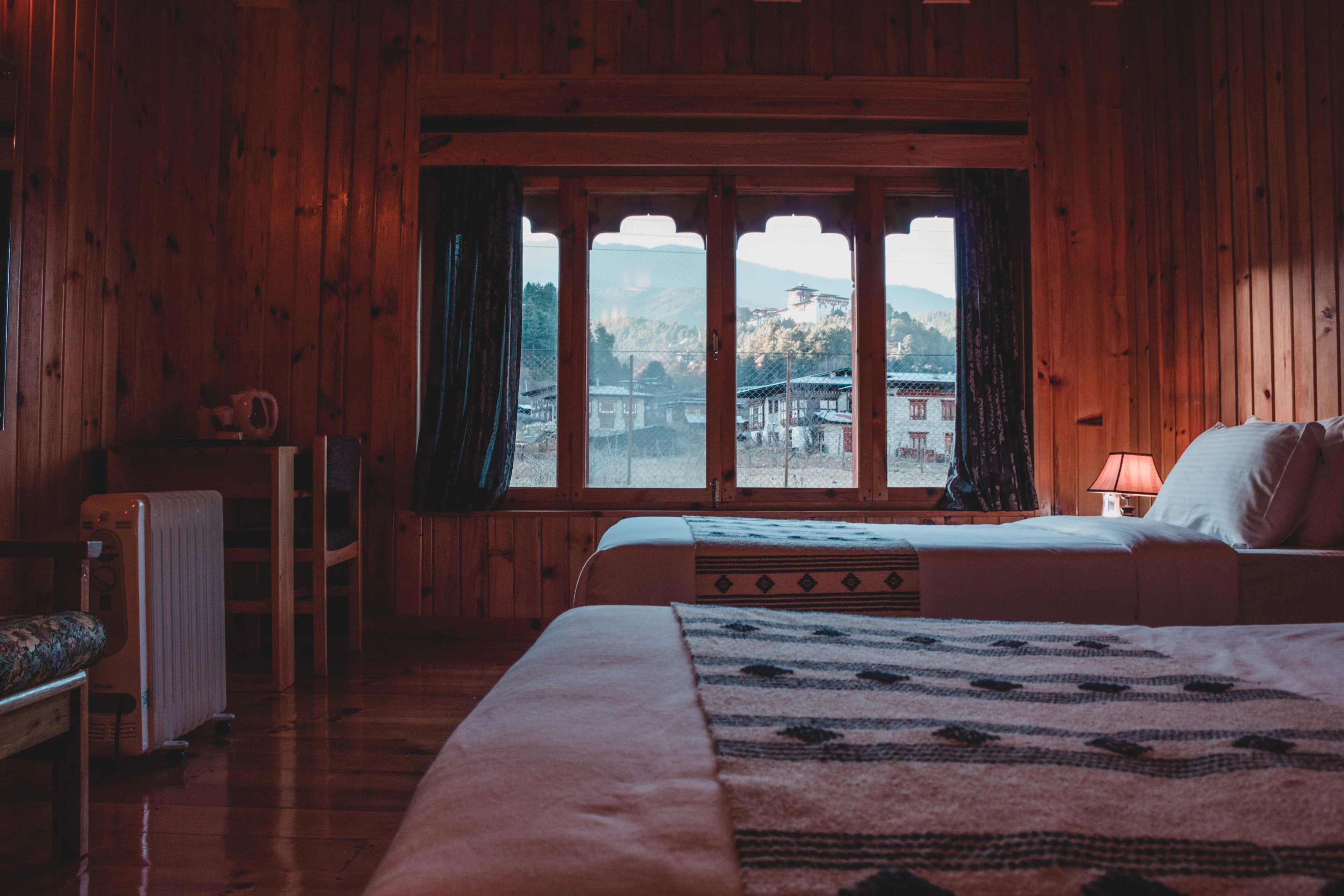 A shot of twin deluxe bed room with Jakar Dzong in the background