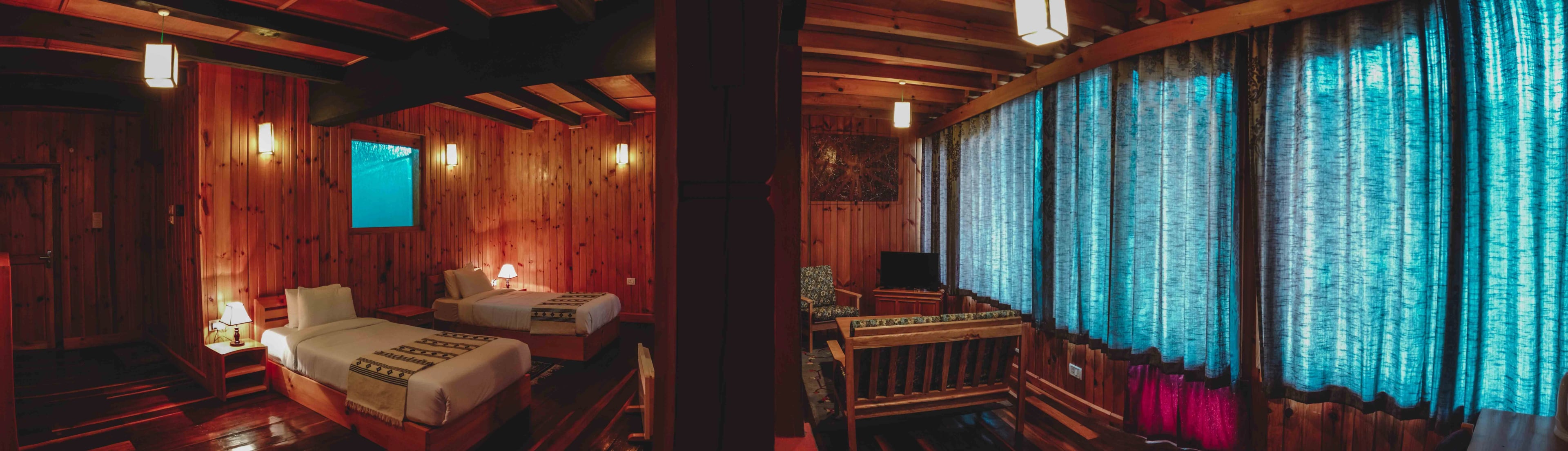 A fish eye shot of Room 203 featuring the twin beds and the sofa lounge area